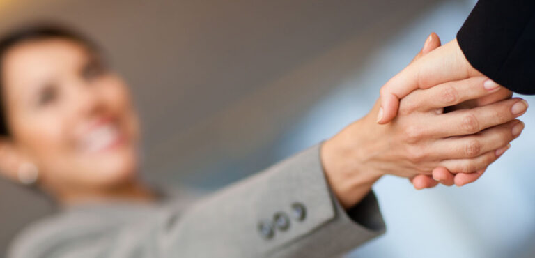 Zwei Personen geben sich die Hand – Symbol für Vertrauen, Zusammenarbeit und geschäftlichen Kontakt